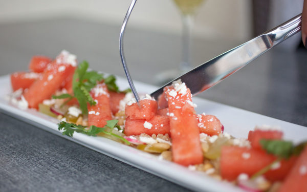 fork and knife cutting food on a plate